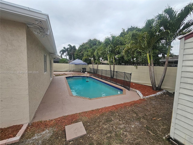 view of swimming pool with a fenced in pool, a fenced backyard, and a patio area