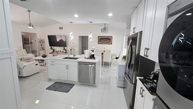 kitchen featuring a sink, stainless steel appliances, vaulted ceiling, white cabinetry, and open floor plan