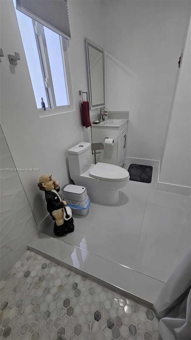 bathroom featuring tile patterned floors, toilet, vanity, and baseboards