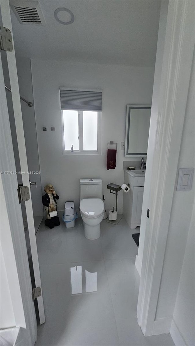 bathroom featuring vanity, toilet, and visible vents