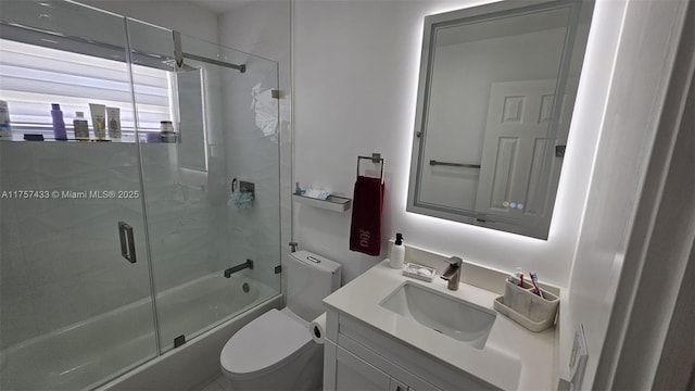 full bathroom featuring enclosed tub / shower combo, toilet, and vanity