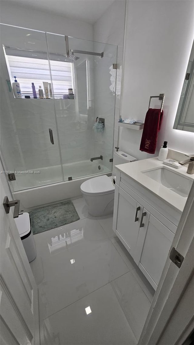 full bath featuring enclosed tub / shower combo, toilet, marble finish floor, and vanity