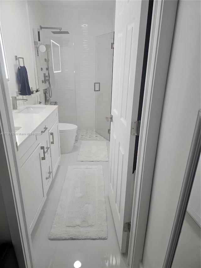 full bath with a shower stall, toilet, double vanity, and a sink