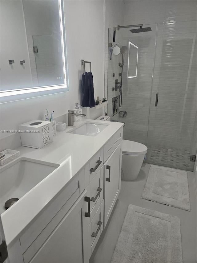 full bath with double vanity, a shower stall, toilet, and a sink