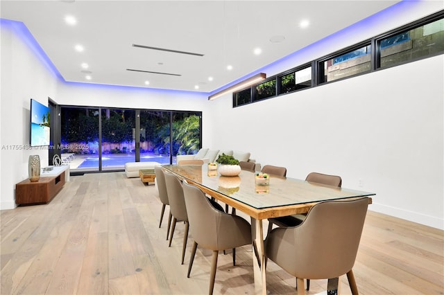 dining space featuring baseboards, light wood finished floors, and recessed lighting