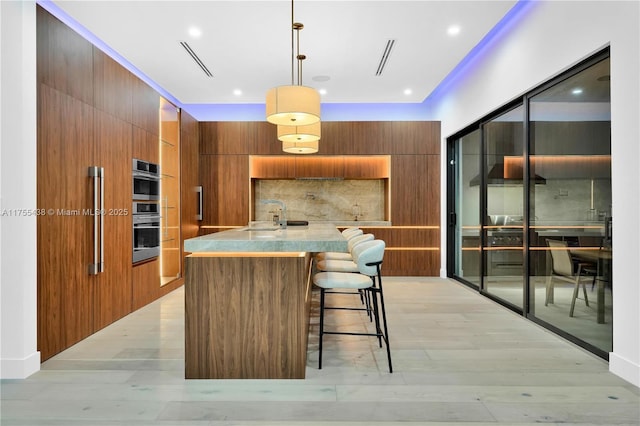 kitchen with brown cabinetry, tasteful backsplash, and modern cabinets