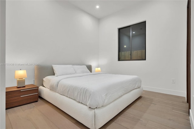 bedroom with light wood-type flooring, baseboards, and recessed lighting