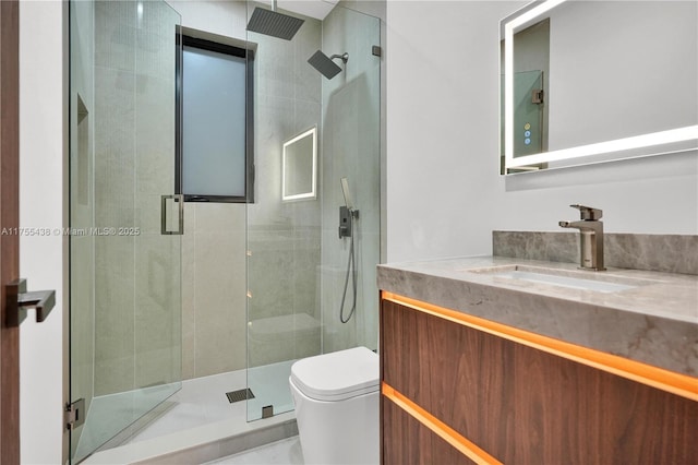 full bathroom featuring a stall shower, vanity, and toilet