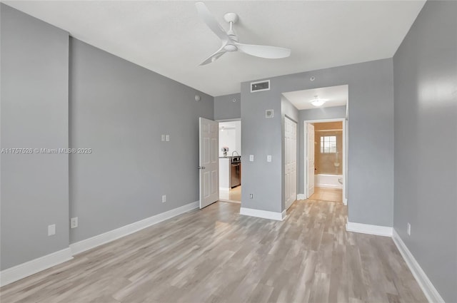 unfurnished bedroom with ensuite bathroom, ceiling fan, visible vents, baseboards, and light wood-type flooring