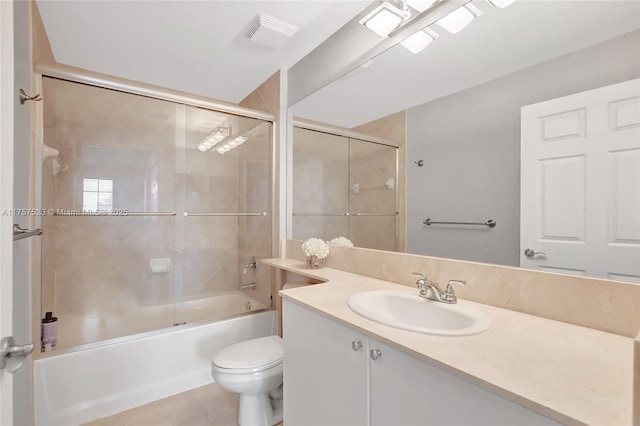 bathroom featuring toilet, shower / bath combination with glass door, visible vents, vanity, and tile patterned floors