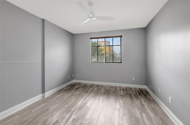 spare room featuring a ceiling fan, baseboards, and wood finished floors