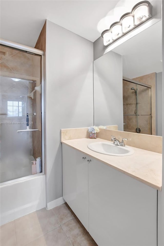 full bathroom with combined bath / shower with glass door, vanity, and tile patterned floors