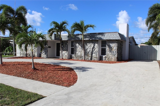 view of front of property featuring stone siding and concrete driveway