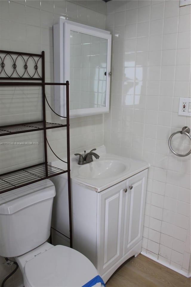 bathroom with vanity, tile walls, toilet, and wood finished floors