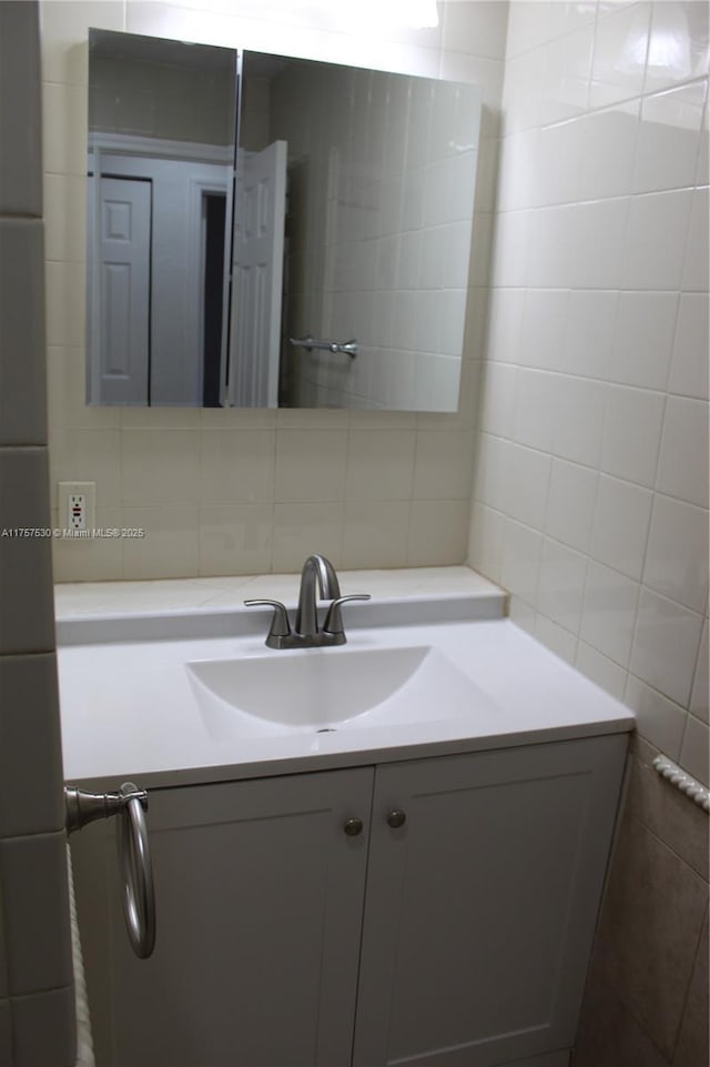 bathroom featuring tile walls, vanity, and decorative backsplash