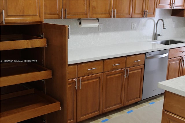 kitchen featuring a sink, brown cabinets, dishwasher, and light countertops