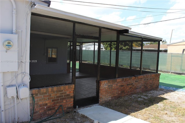 view of patio / terrace featuring a sunroom and fence