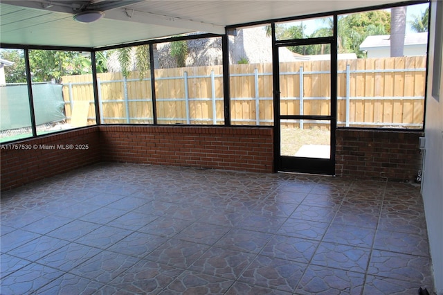 unfurnished sunroom with a ceiling fan