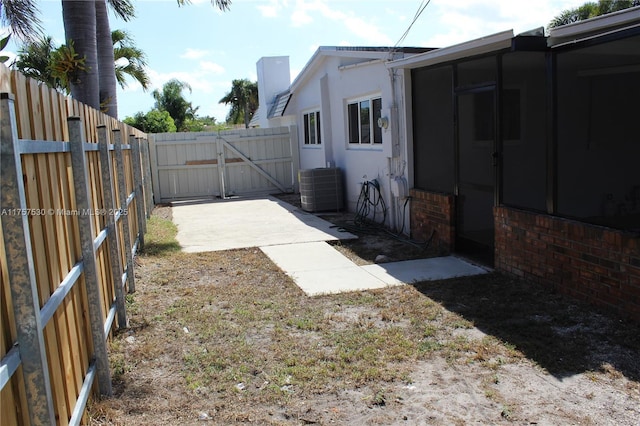 view of yard featuring central AC, fence, and a gate