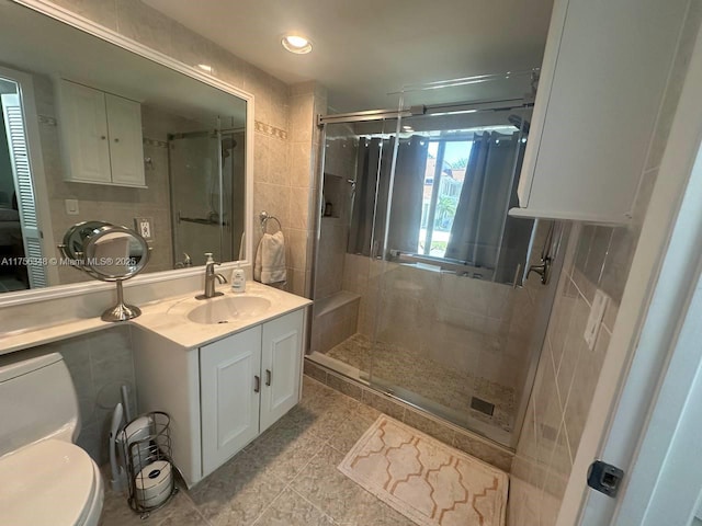 bathroom with toilet, a stall shower, and vanity