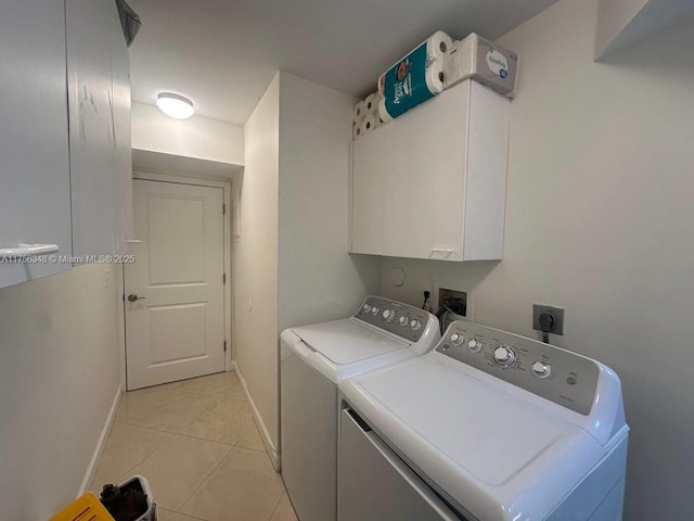 laundry area with light tile patterned floors, baseboards, cabinet space, and separate washer and dryer