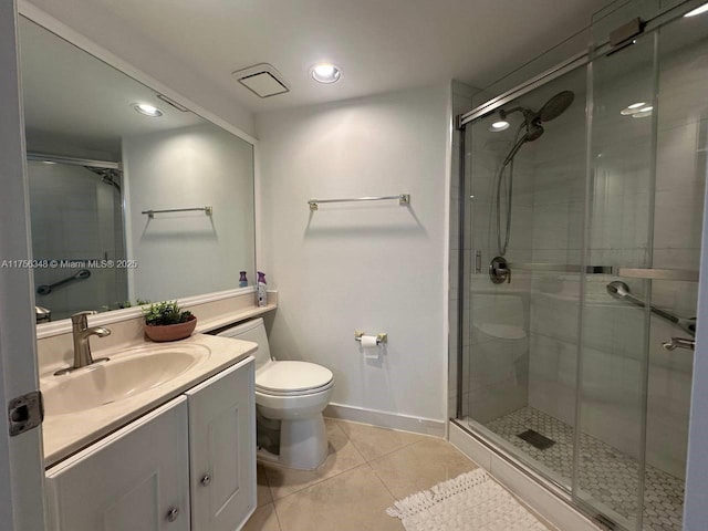 bathroom featuring vanity, tile patterned floors, toilet, and a stall shower