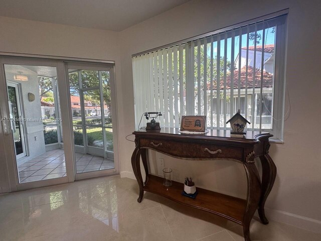 doorway featuring tile patterned flooring and baseboards