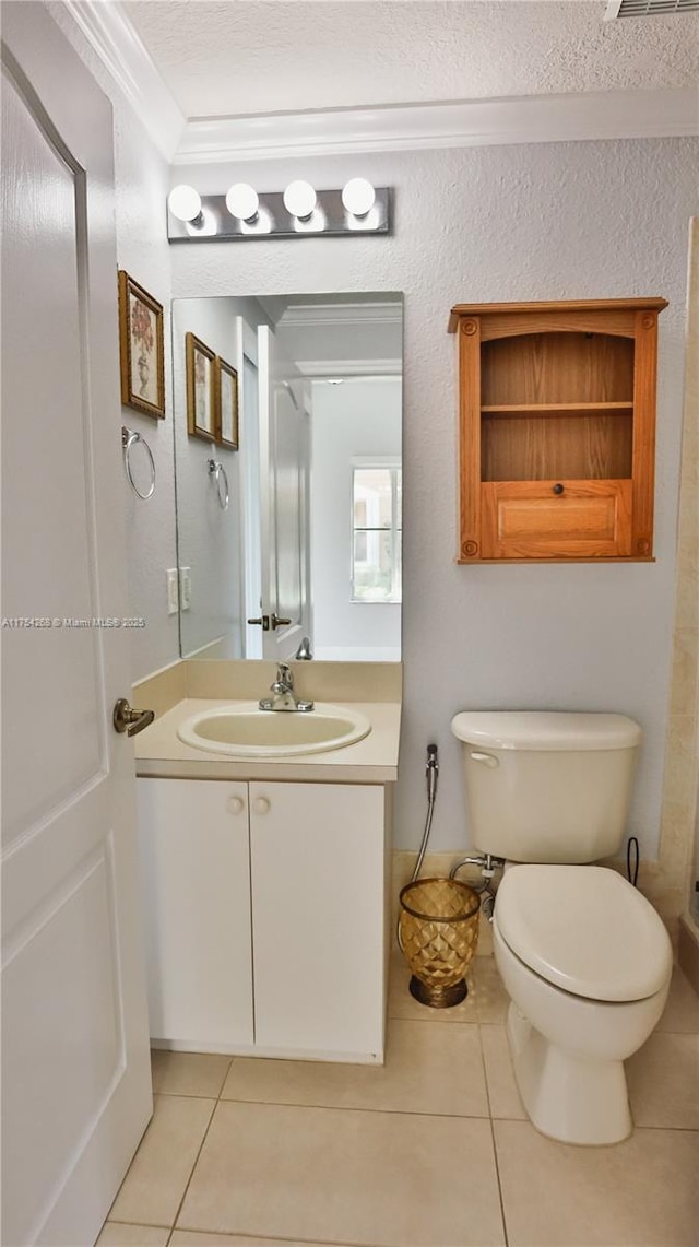 bathroom with toilet, vanity, tile patterned flooring, a textured ceiling, and crown molding