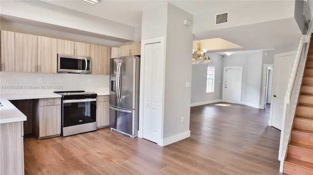 kitchen with light countertops, appliances with stainless steel finishes, modern cabinets, and light brown cabinets