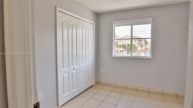 unfurnished bedroom featuring tile patterned flooring and a closet