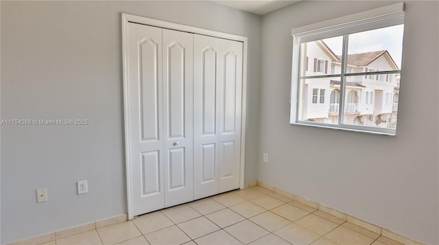 unfurnished bedroom with a closet and light tile patterned flooring