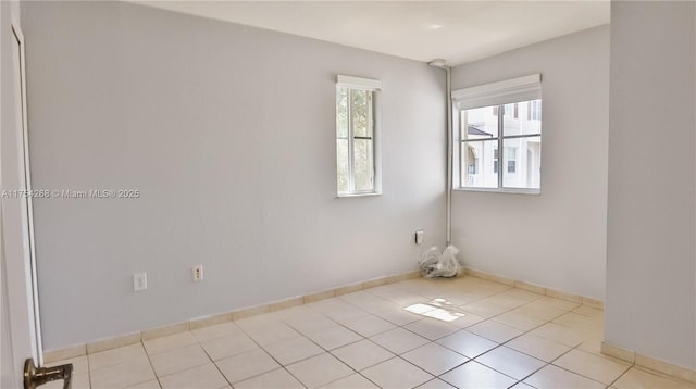 unfurnished room with tile patterned flooring and baseboards