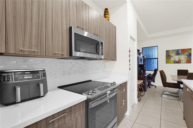 kitchen with light tile patterned floors, stainless steel appliances, modern cabinets, and light countertops