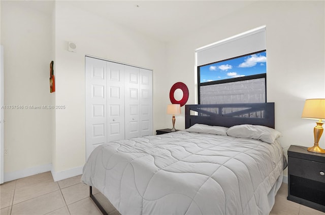 bedroom featuring a closet, baseboards, and light tile patterned floors