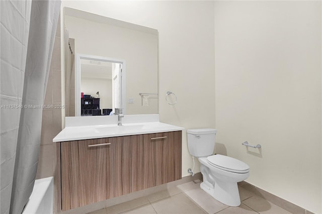 bathroom with toilet, vanity, and tile patterned floors