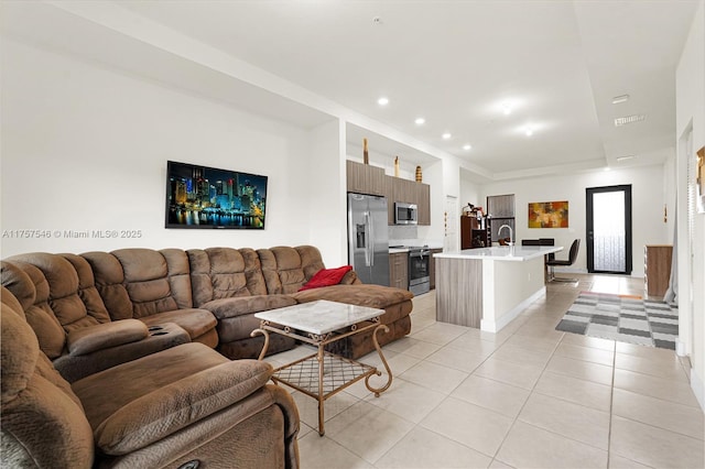 living area featuring light tile patterned floors and recessed lighting