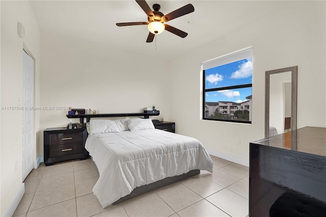 bedroom featuring light tile patterned floors, a ceiling fan, and baseboards