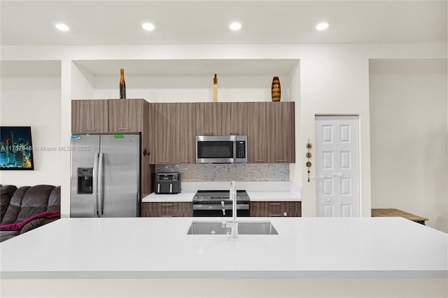 kitchen featuring appliances with stainless steel finishes, tasteful backsplash, light countertops, and modern cabinets