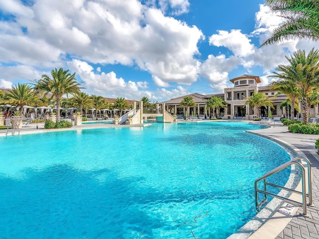 pool with a water slide and a patio