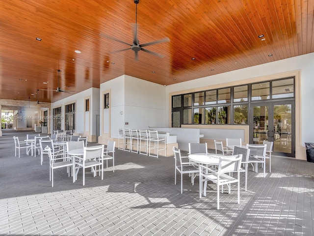 view of patio with outdoor dry bar, outdoor dining area, and a ceiling fan