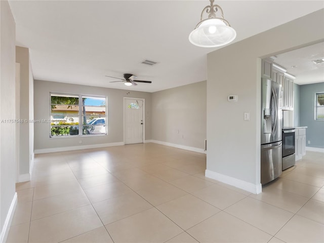 empty room featuring visible vents, ceiling fan, baseboards, and light tile patterned flooring