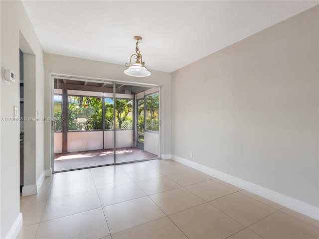 empty room with baseboards and light tile patterned floors