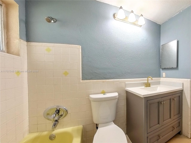 full bath featuring a wainscoted wall, tile walls, and toilet