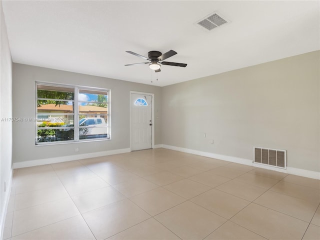 spare room featuring visible vents, ceiling fan, baseboards, and light tile patterned floors