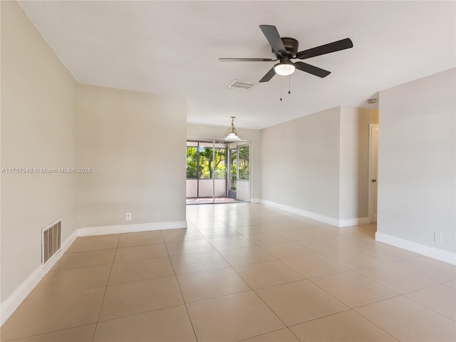 spare room with light tile patterned floors, baseboards, visible vents, and a ceiling fan
