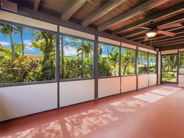 unfurnished sunroom with wooden ceiling, a ceiling fan, and beamed ceiling