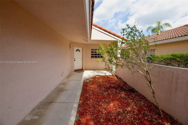 doorway to property with a tiled roof and stucco siding