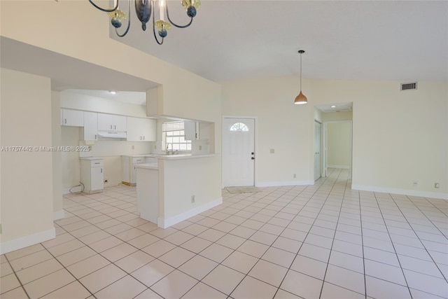 kitchen featuring light tile patterned flooring, a peninsula, visible vents, white cabinets, and open floor plan