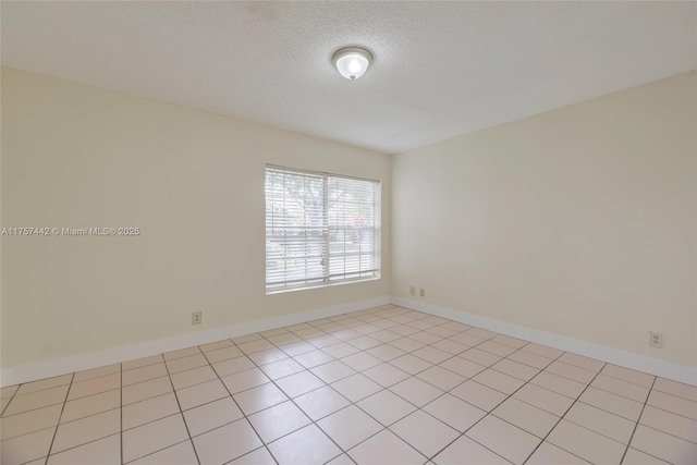 empty room with a textured ceiling and baseboards