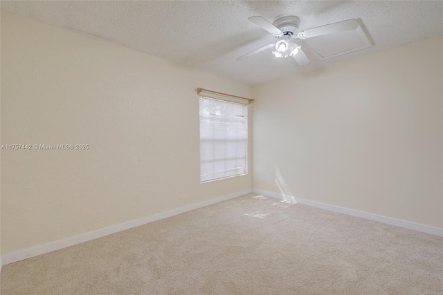 unfurnished room with a textured ceiling, carpet, a ceiling fan, and baseboards